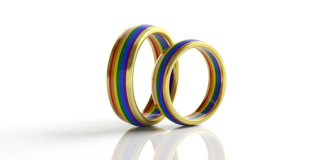 Pair of golden rainbow colors wedding rings isolated on white background, closeup view,